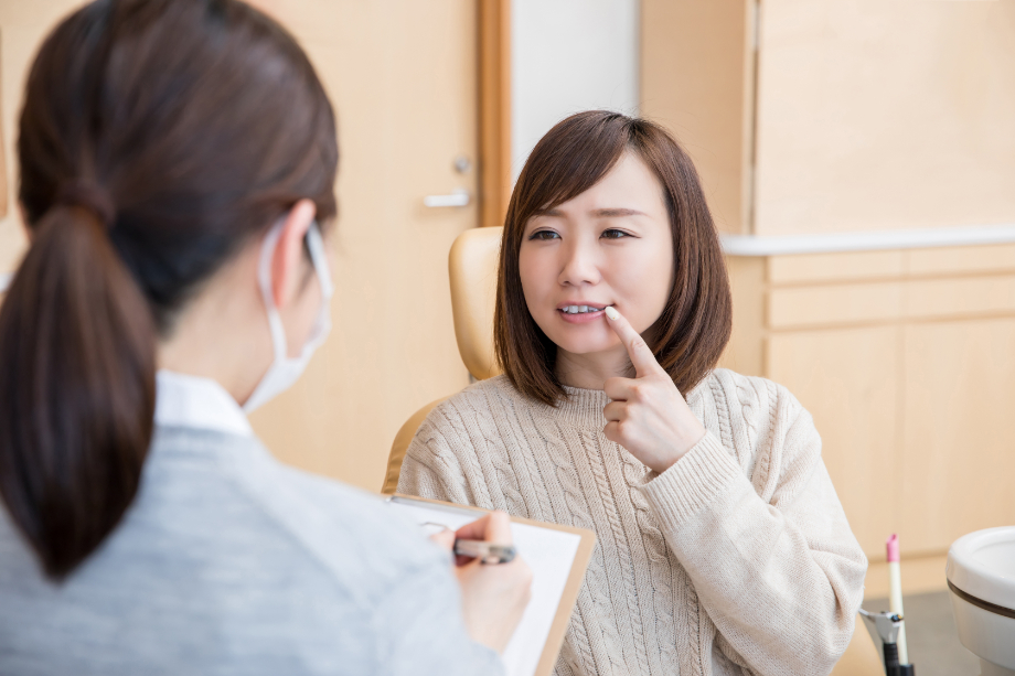 初期虫歯は自分で改善できるか歯科衛生士から説明を受ける女性